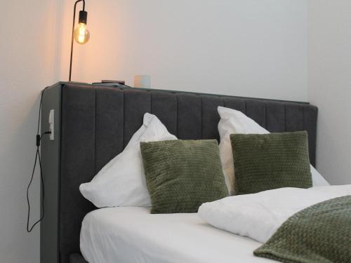 a bed with a black head board with pillows at Modern apartment in the Tyrolean mountains in Fliess