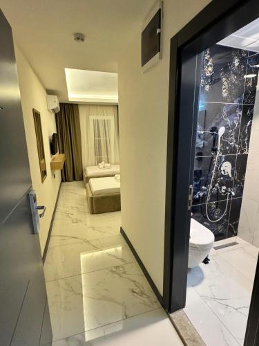 a room with a bathroom with a toilet and a bedroom at Ydora Luxury Hotel in Bodrum City