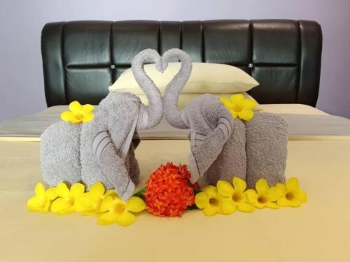 two swans made out of towels and flowers on a bed at OCEAN LODGE in Pantai Cenang