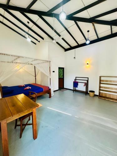a room with a bed and a table in it at Mirissa Villa Green Pepper in Mirissa