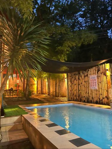 a swimming pool in a backyard with a palm tree at DonnRaqui's Hidden Zen in Iligan