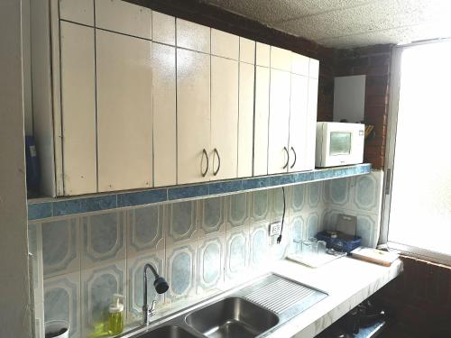 a kitchen with white cabinets and a sink at Acogedor apartamento en Anapoima in Anapoima