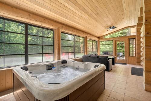 a large bath tub in a room with windows at Fiddler Lake Resort - Bear 25 in Mille-Isles