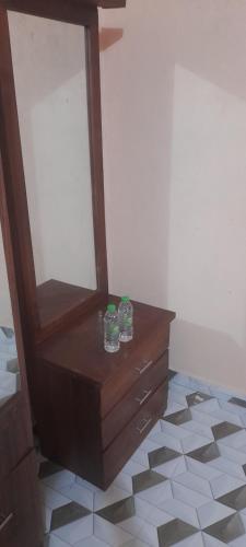 two glasses sitting on a dresser with a mirror at Rani Alfred in Viramanikkatevanturai