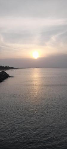 a sunset over a large body of water at Rani Alfred in Viramanikkatevanturai