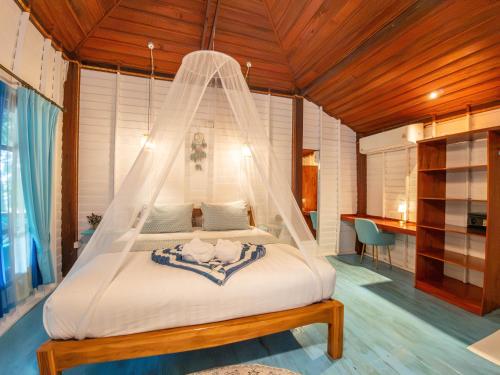 a bedroom with a bed with a mosquito net at Baan Kiao in Haad Yao