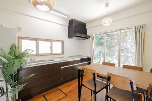 a kitchen with a wooden table and a sink at 栞-shiori-NAKASONE in Miyako-jima