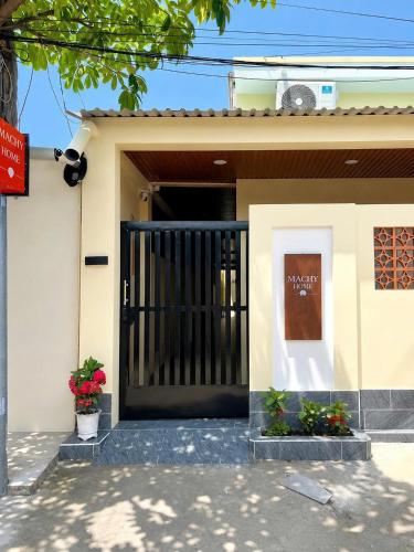 a house with a black gate in front of it at Machy Home in Phú Quốc