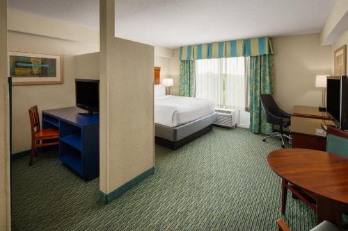 a hotel room with a bed and a desk at Holiday Inn Resort Orlando - Lake Buena Vista by IHG in Orlando