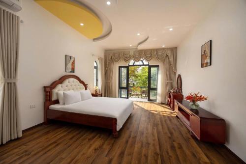 a bedroom with a bed and a large window at Sunstone Villa in Trung Gia