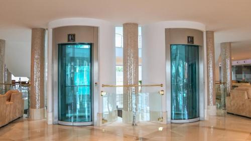 two glass elevators in a room with at Hotel Granada Palace, Affiliated by Melia in Monachil