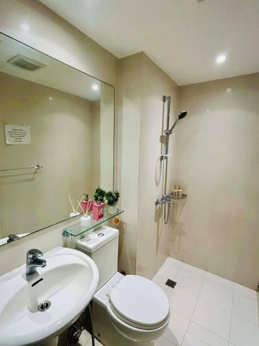 a bathroom with a toilet and a sink and a mirror at Affordable Staycation at Azure Urban Resort Residences Near NAIA in Manila