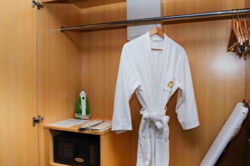 a white robe hanging on a rack in a room at Ming Garden Hotel in Kota Kinabalu