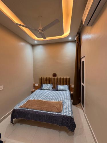 a bedroom with a bed and a ceiling at Sunita Kunj in Jhūsi