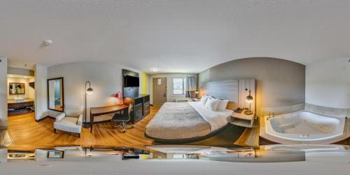 a hotel room with a large bed and a tub at Quality Inn in Helen