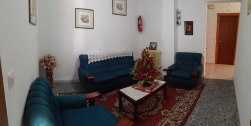 a living room with blue furniture and a christmas tree at Hostal Mulhacen in Trevélez
