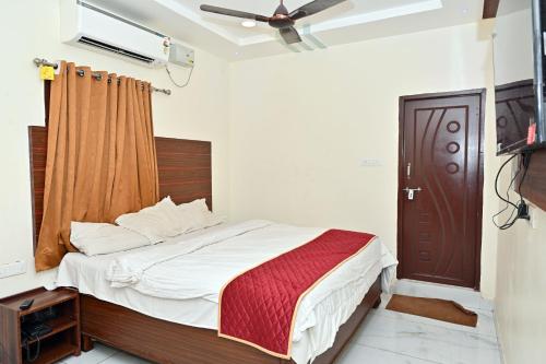 a bedroom with a bed and a brown door at Hotel Siddveer Grand in Guntūr