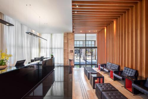 a lobby with black chairs and a long bar at Hotel Brasil 21 Convention, Affiliated by Meliá in Brasília