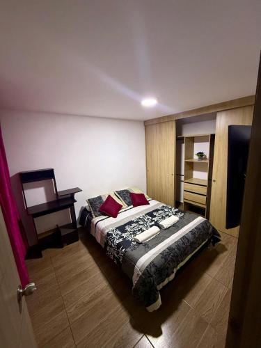 a bedroom with a bed and a television in it at Fly At Home Bogotá in Bogotá