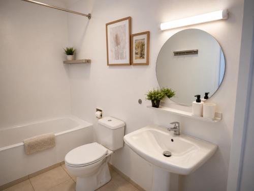 ein Badezimmer mit Toilette, Waschbecken und Spiegel in der Unterkunft Pasithea Holiday Apartments in Larnaka