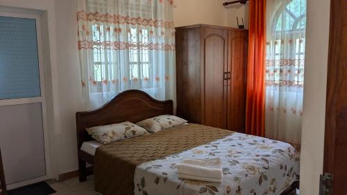 a bedroom with a bed in a room with windows at Margarita Leisure in Wadduwa