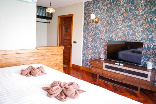 a bedroom with a bed and a flat screen tv at Salty Pearl Beach Front Phuket in Patong Beach