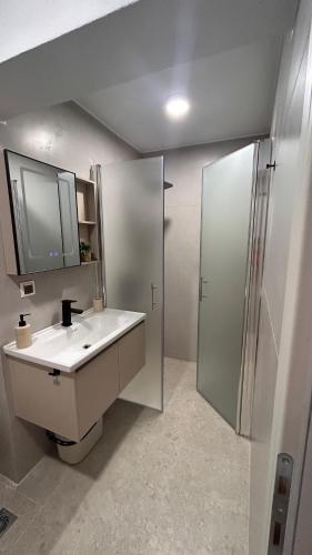 a bathroom with a sink and a shower at Sigma Exotic Palio Beach Apartment in Paleo Tsifliki