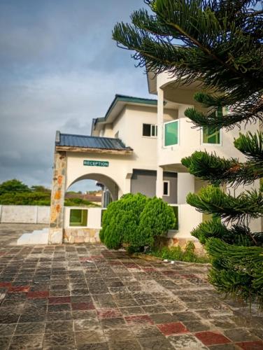 a building with a tree in front of it at Floyds Beach Resort & Spa in Nyanyanu