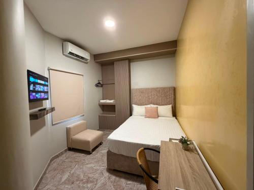 a small room with a bed and a table at HOTEl LA CANDELARIA ROOM HOUSE in Mangue