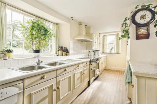 a kitchen with white cabinets and a sink at Parnacott in Pancrasweek