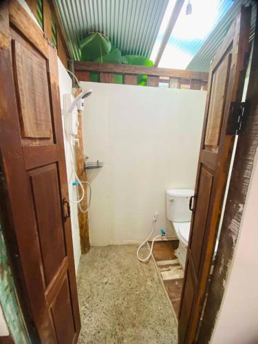 a small bathroom with a toilet and a door at Banana garden in Pai