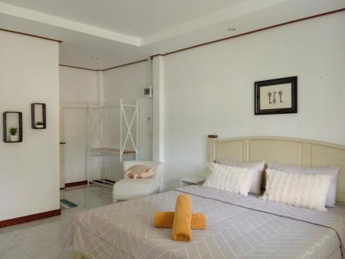 a bedroom with a bed with yellow towels on it at เขายัอยวาเล่ย์ in Khao Yoi
