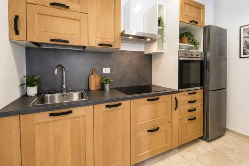 a kitchen with wooden cabinets and a stainless steel refrigerator at Carducci Mare e Monti in Pescara