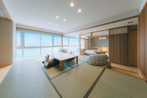 a living room with a table and a bedroom at Toba Grand Hotel in Toba