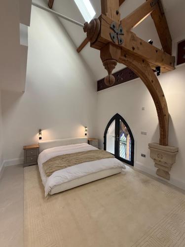a bedroom with a large bed with a wooden ceiling at The Apse in Stotfold