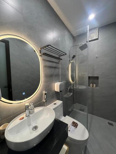 a bathroom with a sink and a mirror and a toilet at Saka Hotel in Plei Brel (2)