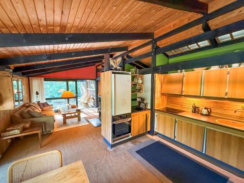 a kitchen with wooden ceilings and a living room at Architectdesigned 1976 Summer House Near Beach in Store Fuglede