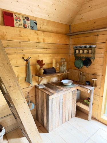 a kitchen in a log cabin with wooden walls at Glamping Olivia v lese in Radíč
