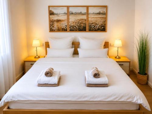 a bedroom with a white bed with towels on it at Panoramablick mit Premium-Wanderwegen vor der Haustür in Albstadt