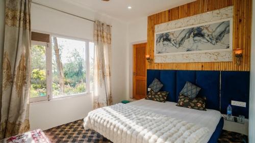 a bedroom with a bed with a blue headboard and a window at Hariparbatview in Srinagar