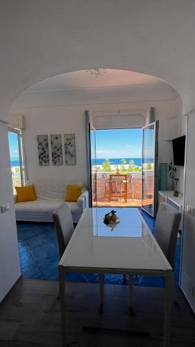a living room with a table and a view of the ocean at Casa Emi in Amalfi