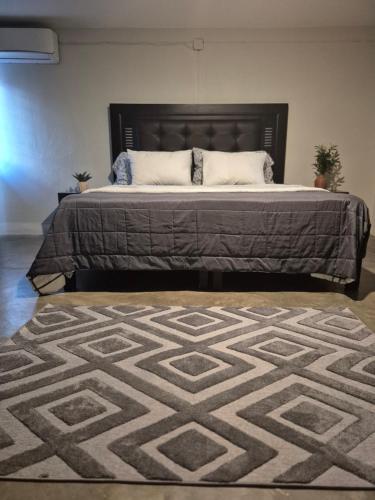 a bedroom with a large bed with a rug at Studio 40 in Tequila