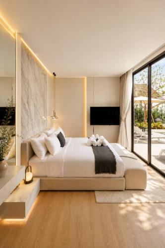 a bedroom with a large bed and a large window at Le Da Villas 5BR Bang Tao Beach in Laguna Phuket