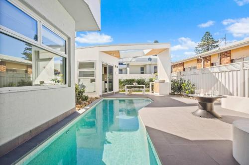 a swimming pool in the backyard of a house at The Grand Ocean Vista in Shellharbour