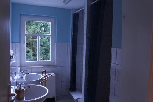 a bathroom with two sinks and a window at HerrBerge Pilgerglück in Eibenstock