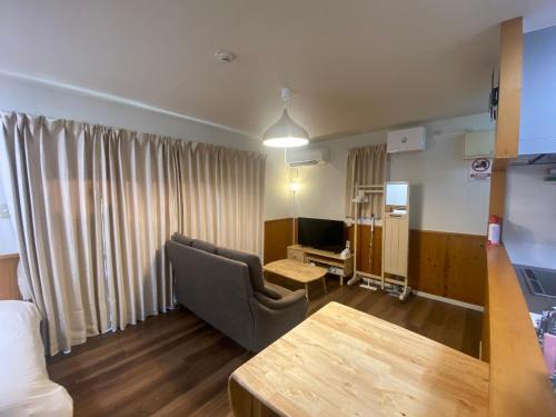 a living room with a couch and a table at Bise House in Motobu