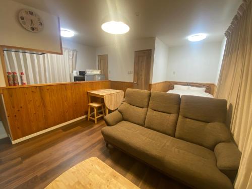 a living room with a couch and a bed at Bise House in Motobu