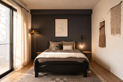 a bedroom with a bed with a black wall at Chloechen Home in Taitung City
