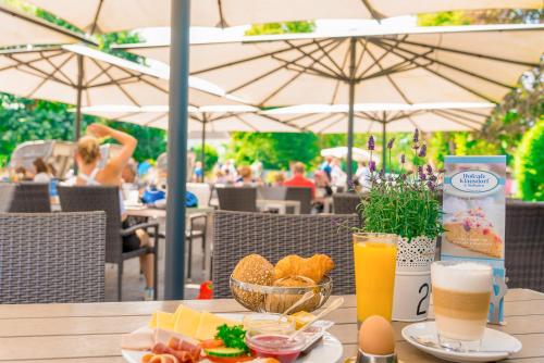 a table with food and two glasses of orange juice at Bauernhof Lafrenz, Ferienhäuser & Hofcafé in Fehmarn