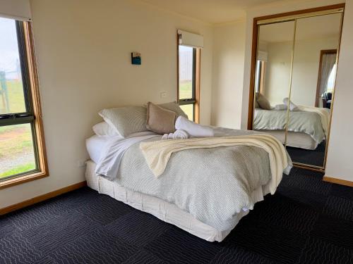 a bedroom with a bed and a large mirror at Devils Gap in Currie